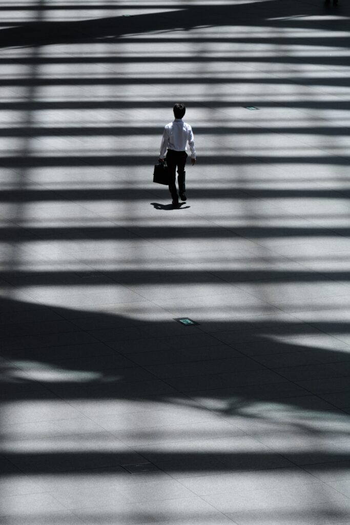 man walking down in a corporate looking environment while wearing a suit